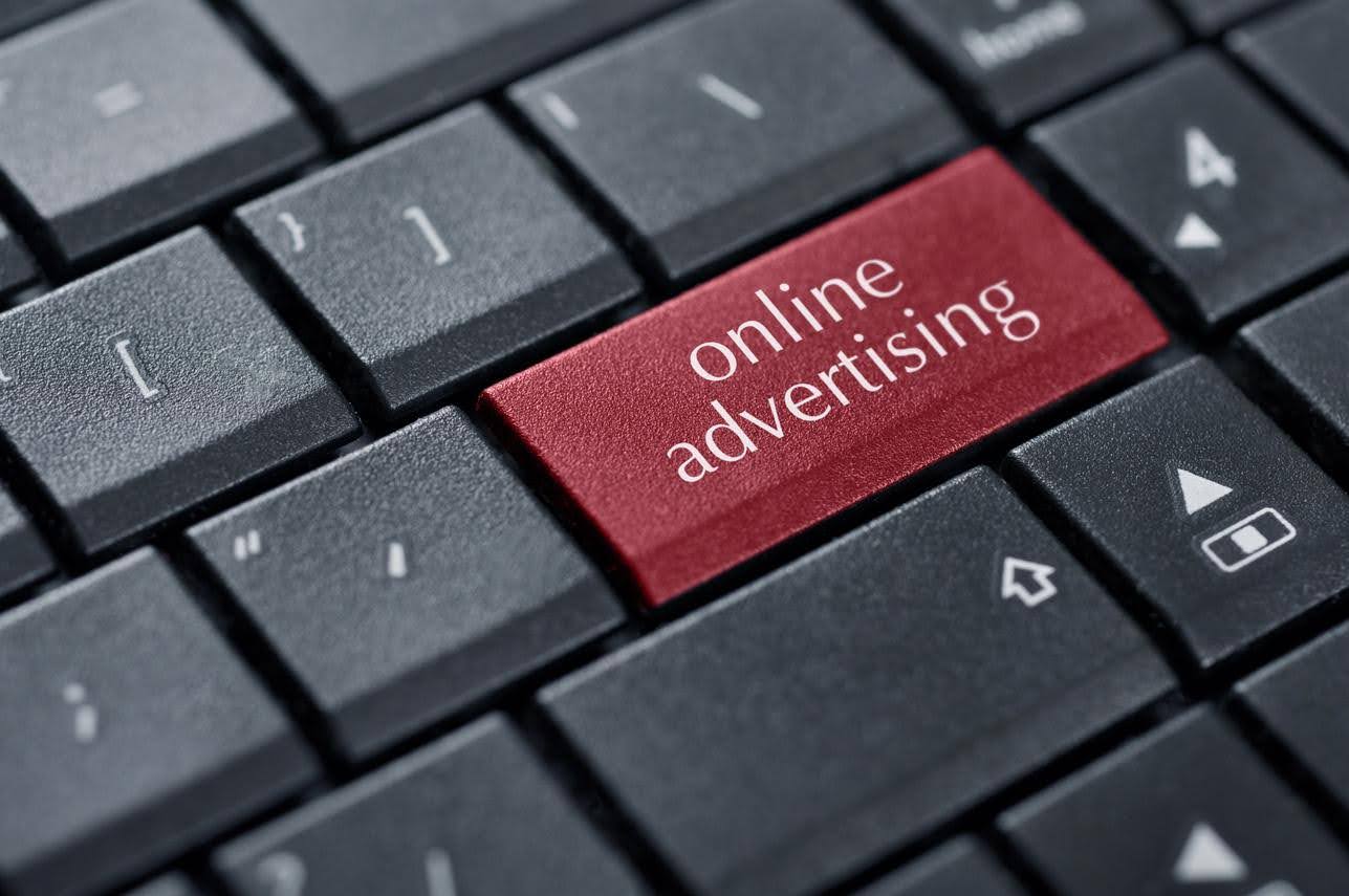 Close-up of a computer keyboard with a red key labeled 'online advertising,' representing affordable digital marketing strategies for small businesses.