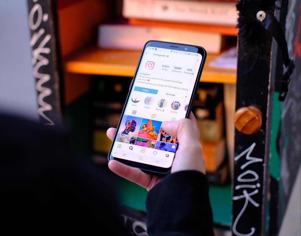 Person holding a smartphone with the Instagram app open, representing creative Instagram content ideas for local businesses.