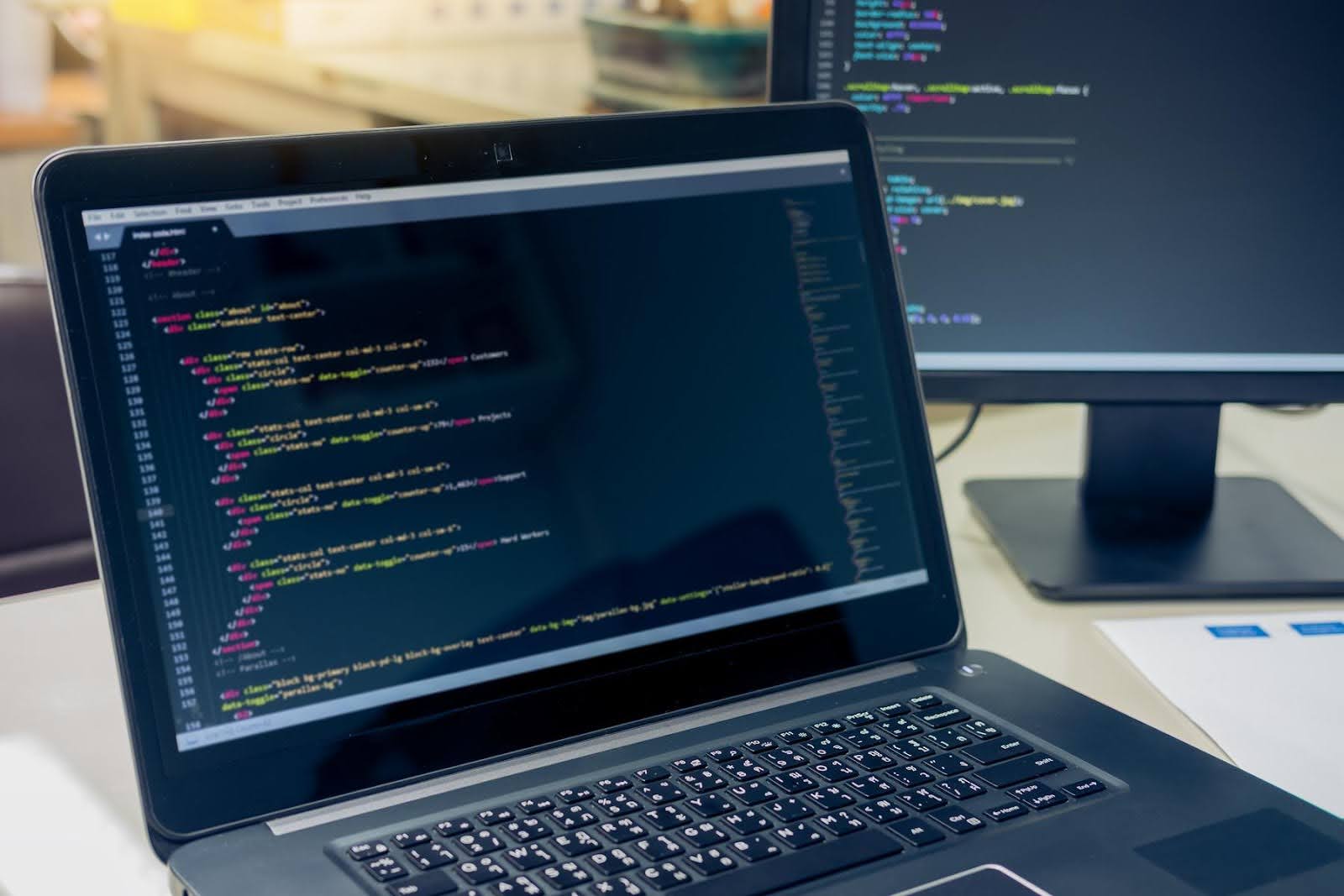 Laptop screen showing lines of website code, symbolizing hidden web development red flags that agencies don’t often disclose.