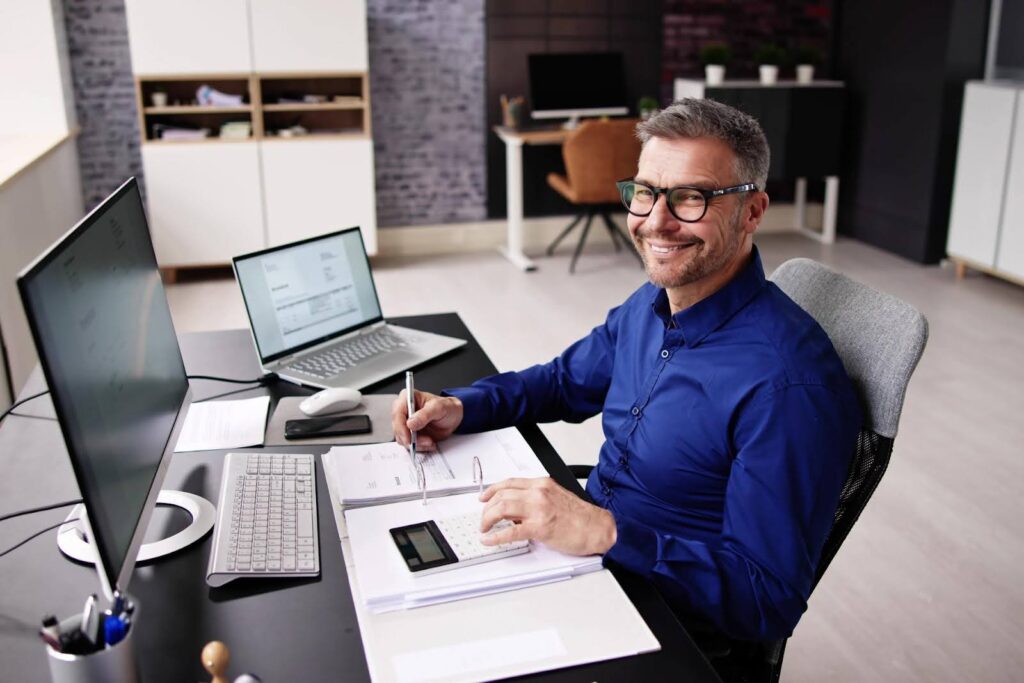 Tech Fellow explaining QuickBooks bookkeeping needs, showing a business owner reviewing financial records and using QuickBooks software to manage accounts and bookkeeping tasks.