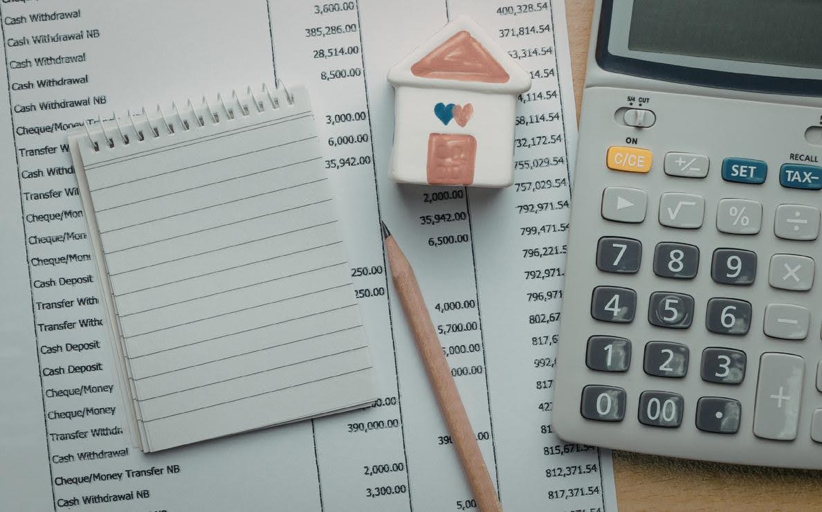 Techfellow helping creative professionals with Quarterly tax planning, shown by financial statements, a calculator, notebook, and budgeting tools used to organize income and expenses.