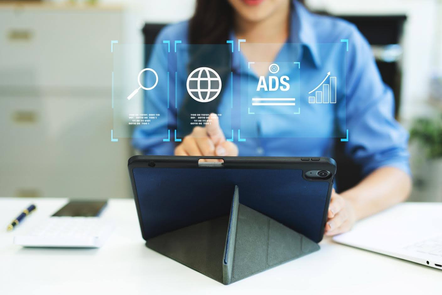 Digital marketing professional using a tablet with search, online advertising, and growth analytics icons to improve small business visibility and marketing performance.