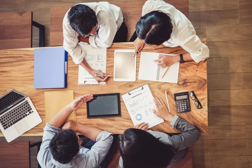 Business team reviewing marketing reports and sales performance data to help small businesses improve client follow-ups and convert inquiries into sales.